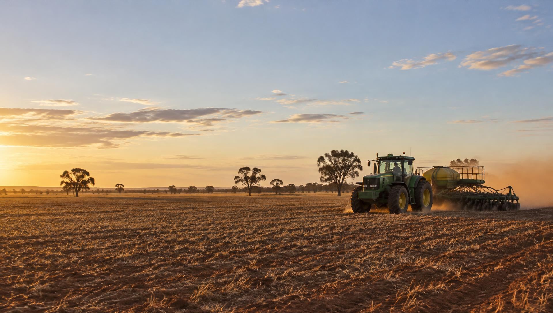 A tractor sowing a wide paddock on an Australian farm